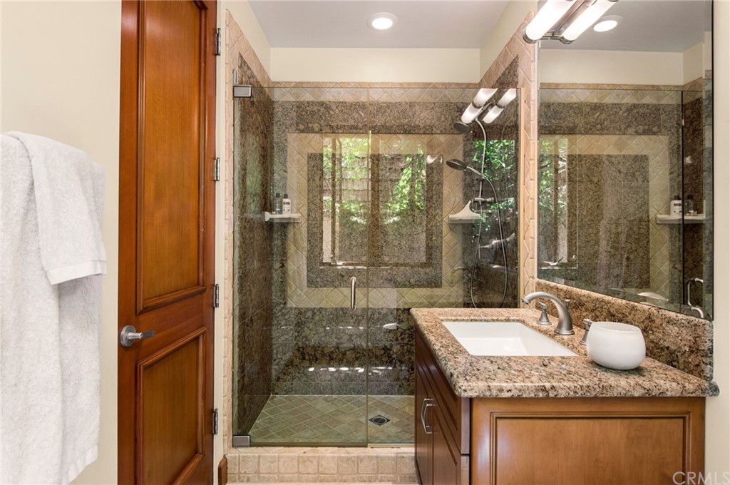 10 Smithcliffs Road Laguna Beach, CA 92651 - Photo 22 of 38 a bathroom with a granite countertop sink a mirror and shower