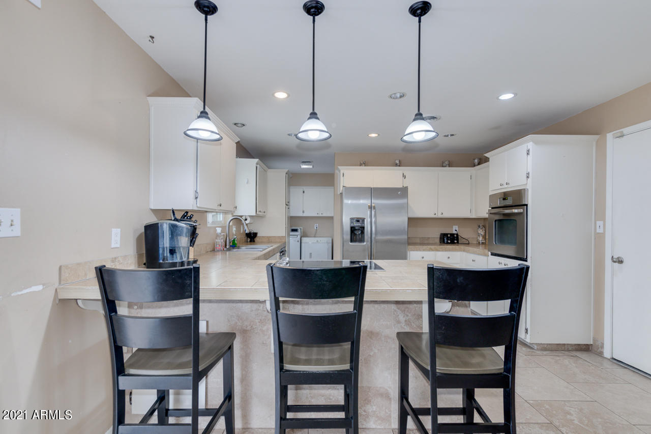4215 West Dailey Street Phoenix, AZ 85053 - Photo 12 of 32 a dining room with stainless steel appliances kitchen island a table and chairs