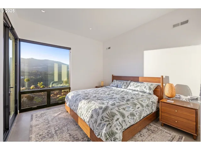 a bedroom with a bed and large window