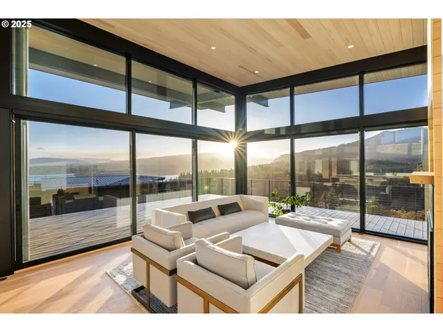 a living room with a floor to ceiling window and wooden floor