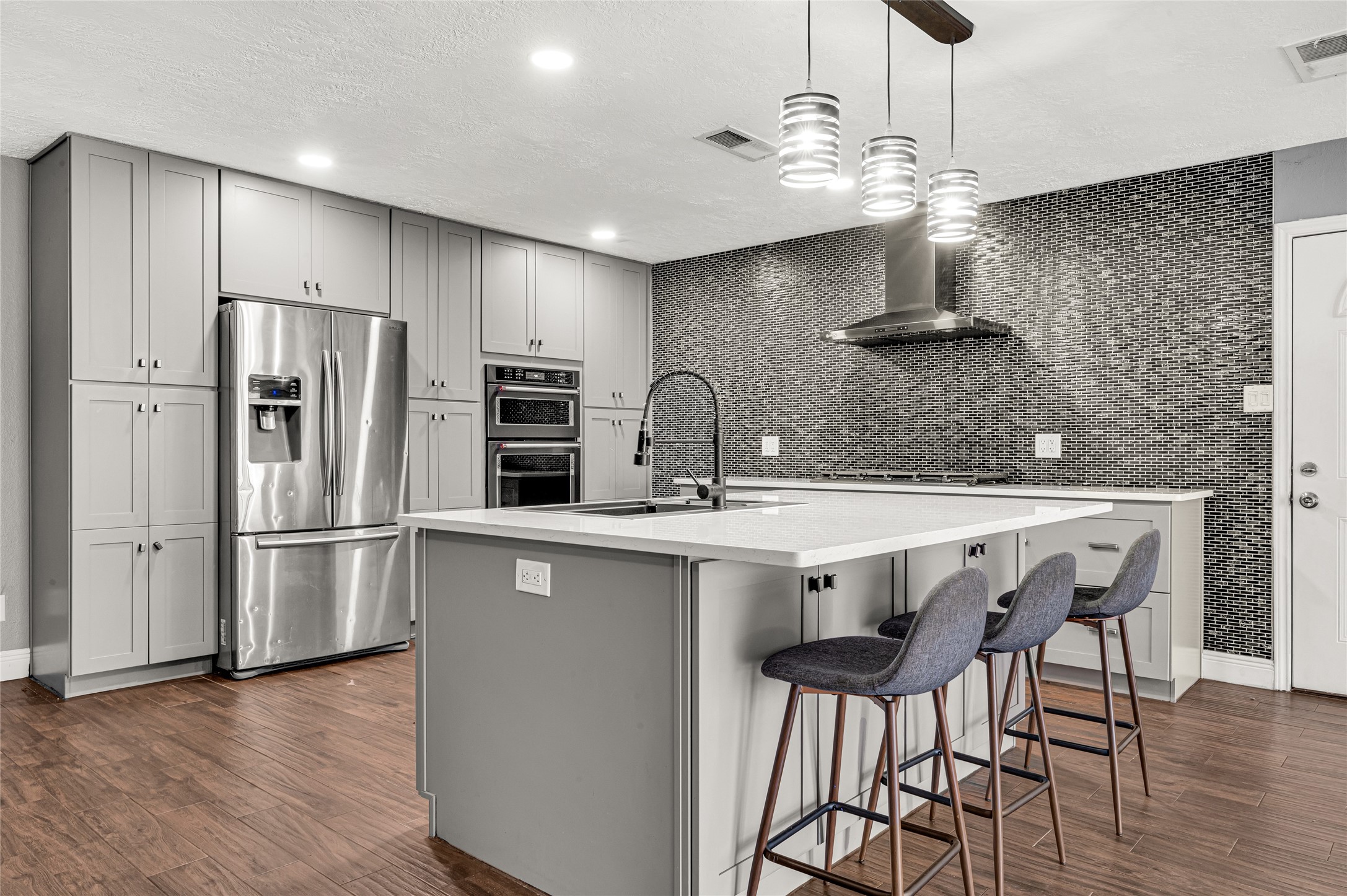 4170 Amir Street Houston, TX 77072 - Photo 5 of 18 a kitchen with stainless steel appliances a kitchen island hardwood floor and a sink