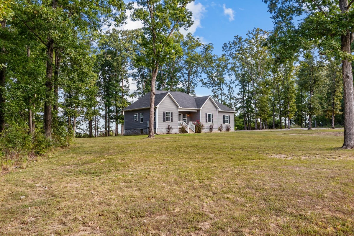 a front view of a house with a yard and trees