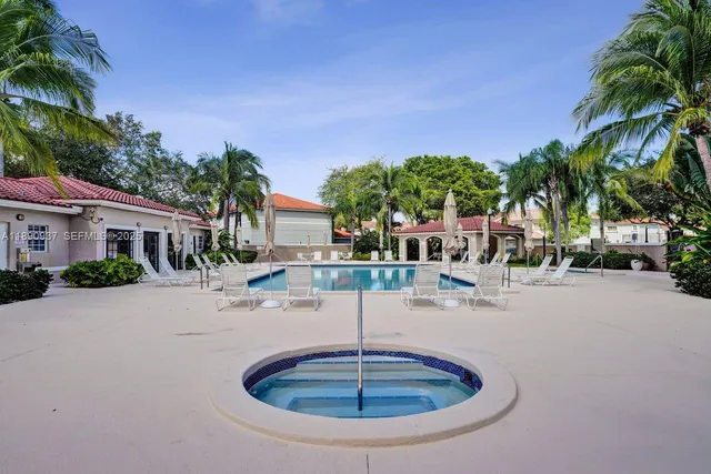 front view of house with a yard and palm trees