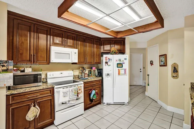 a view of a kitchen with refrigerator and window