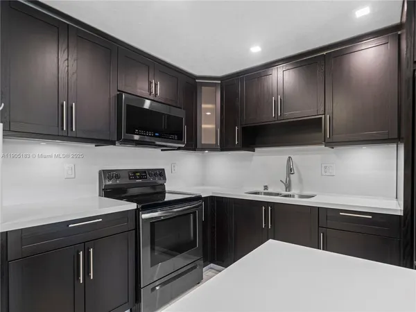 a kitchen with stainless steel appliances a stove sink microwave and cabinets