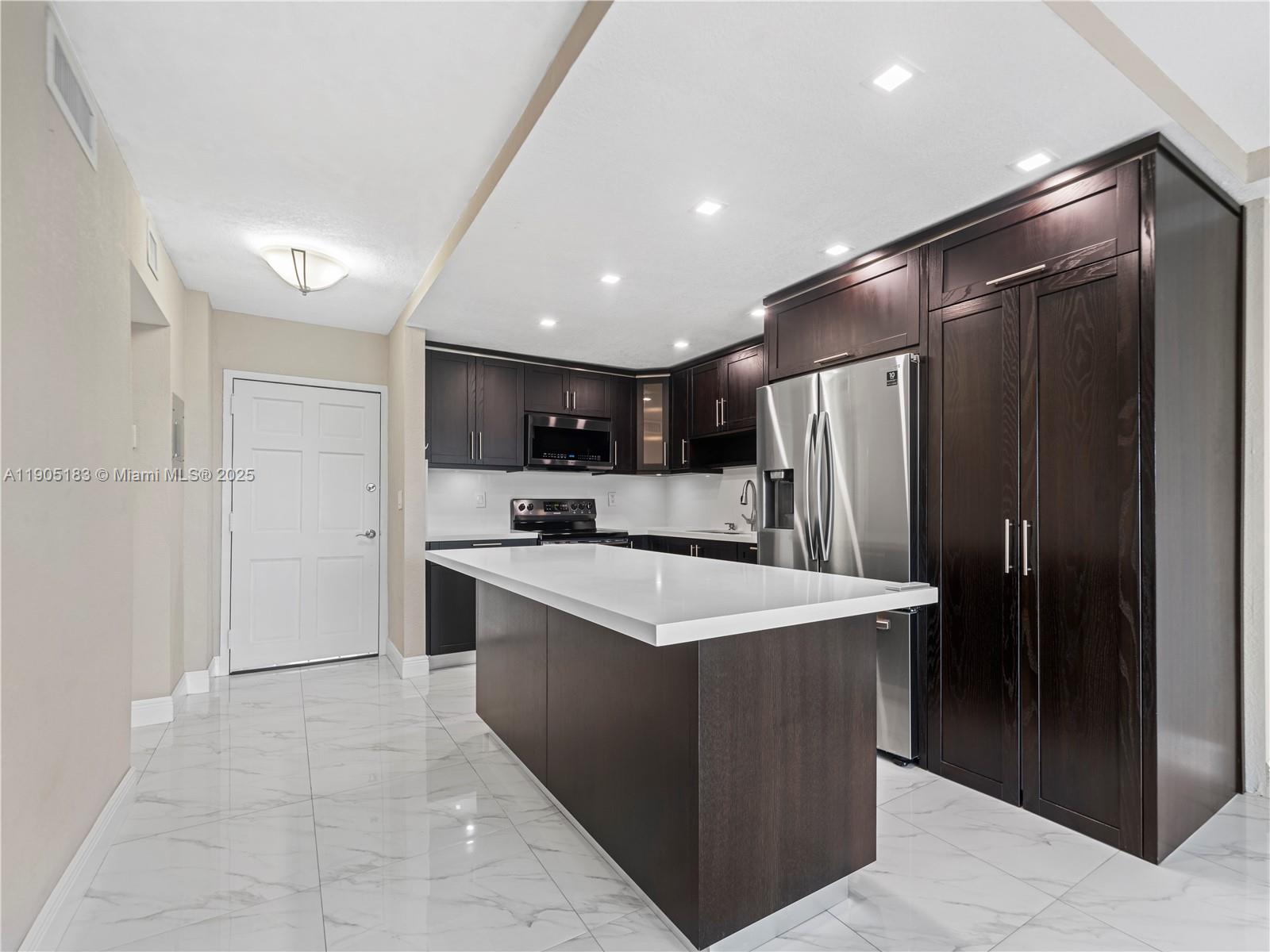 1800 Northwest 24th Avenue, Unit 1019 Miami, FL 33125 - Photo 4 of 14 a kitchen with stainless steel appliances a refrigerator a sink dishwasher with a stove and refrigerator