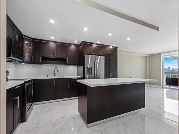 a large kitchen with stainless steel appliances kitchen island granite countertop a sink and cabinets