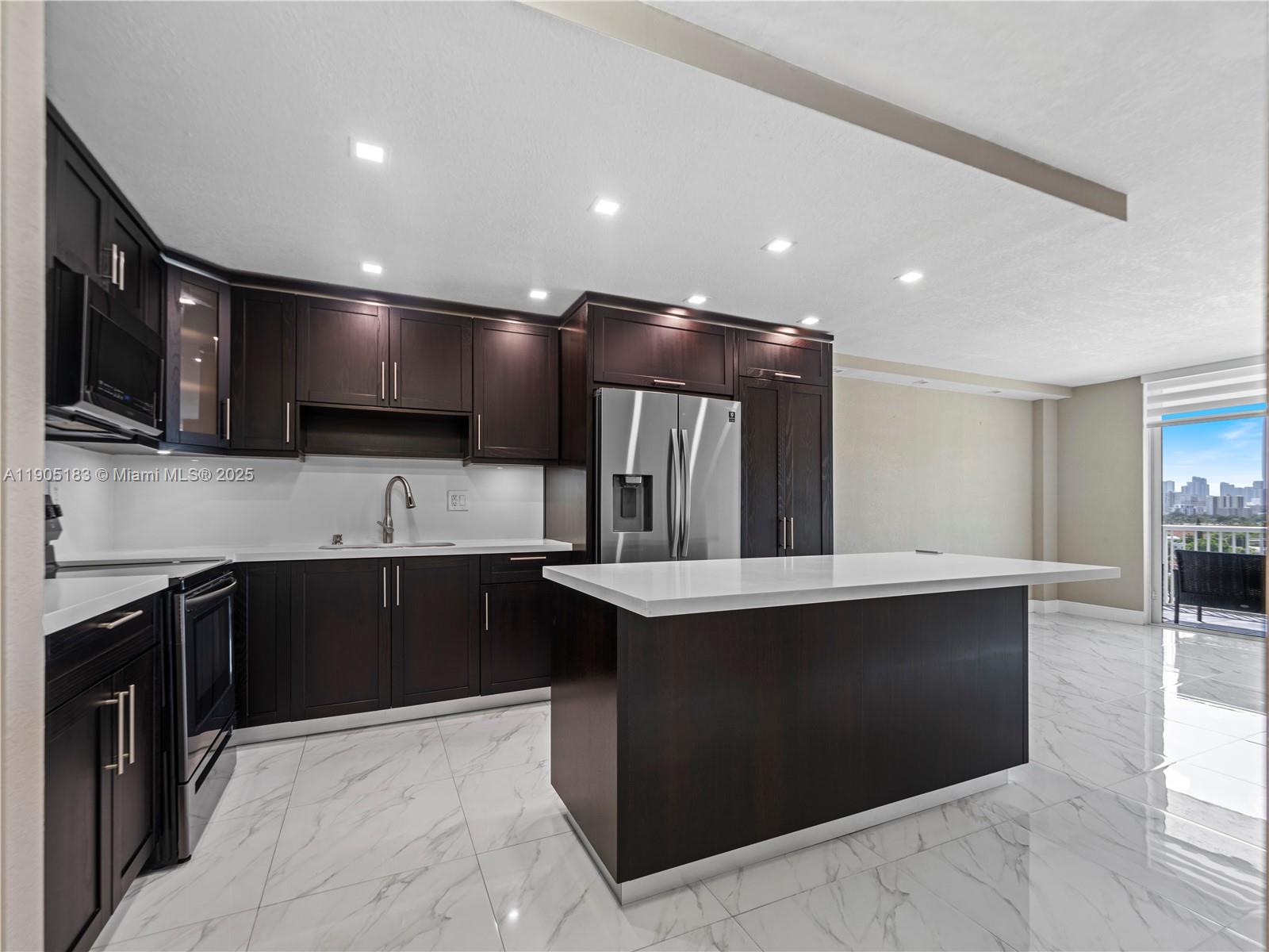 1800 Northwest 24th Avenue, Unit 1019 Miami, FL 33125 - Photo 5 of 14 a large kitchen with stainless steel appliances kitchen island granite countertop a sink and cabinets