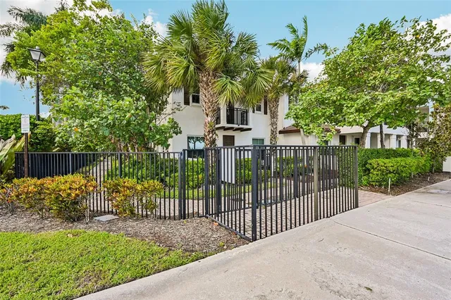 a view of a house with a yard and palm trees