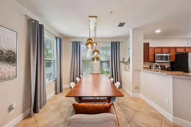 a living room with furniture a chandelier and a dining table