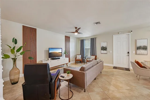 a living room with furniture a flat screen tv and a table