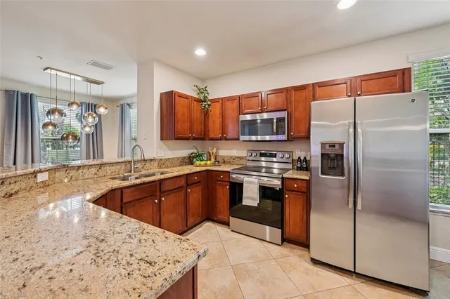 a kitchen with stainless steel appliances granite countertop a refrigerator and a sink