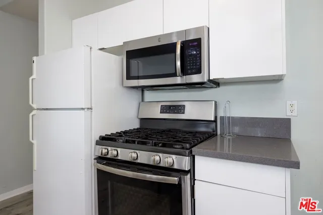 a kitchen with stainless steel appliances granite countertop a stove and a microwave