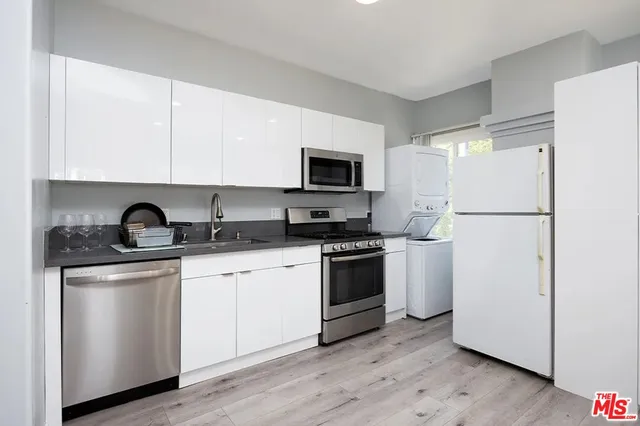 a kitchen with stainless steel appliances granite countertop a refrigerator stove a sink and a microwave