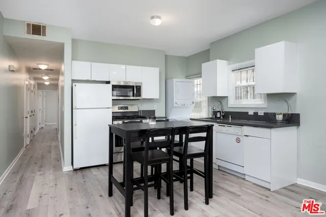 a kitchen with a refrigerator a stove a sink and chairs