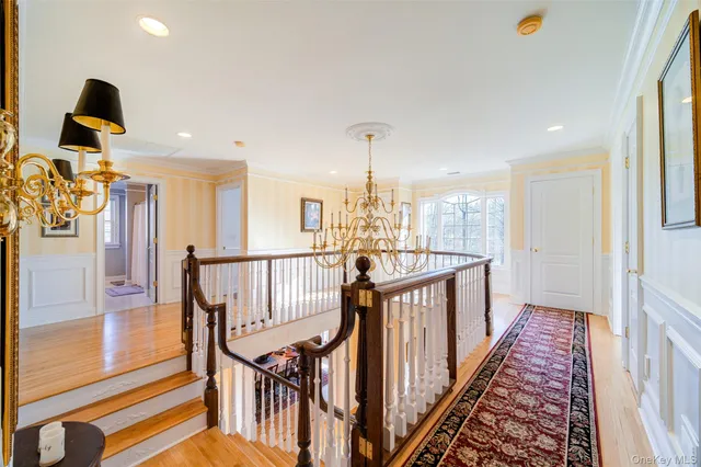 a view of a hallway with wooden floor and stairs
