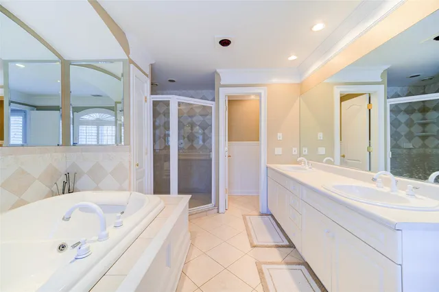a spacious bathroom with a tub sink shower and mirror