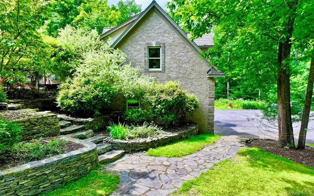 a front view of a house with a yard and potted plants