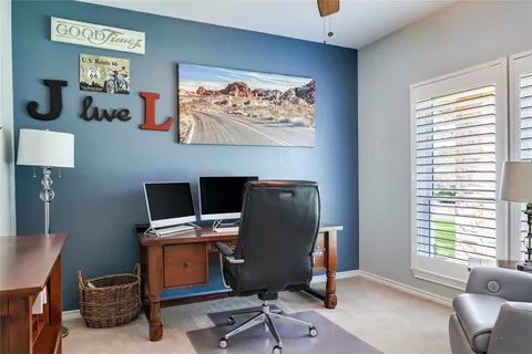 a view of a workspace with furniture and a window