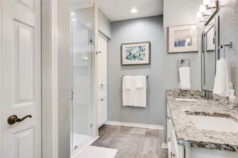 a bathroom with a granite countertop shower and a sink