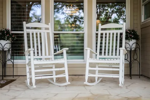 a view of a porch with a table and chairs