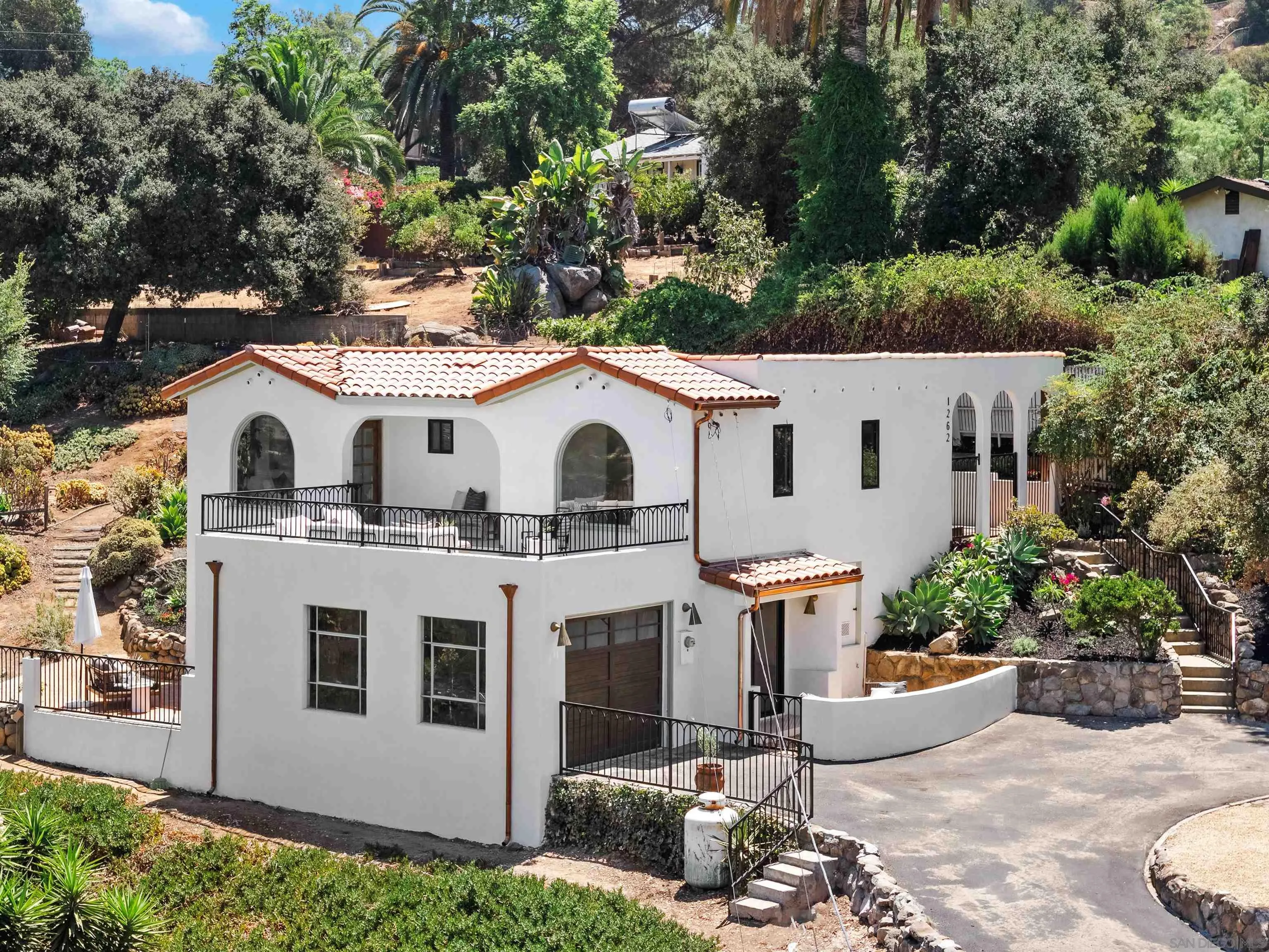 1262 Horizon Ridge El Cajon, CA 92020 - Photo 1 of 68 a view of a white house with a small yard plants and large tree