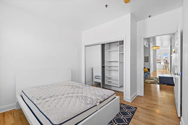 a room with a bed and wooden floor