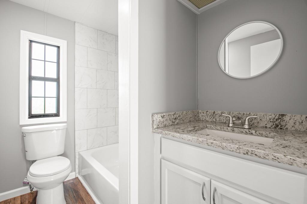 710 Athens Road Lexington, GA 30648 - Photo 17 of 17 a bathroom with a granite countertop sink toilet and a mirror