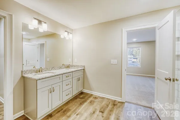 a bathroom with a granite countertop sink a mirror and a shower