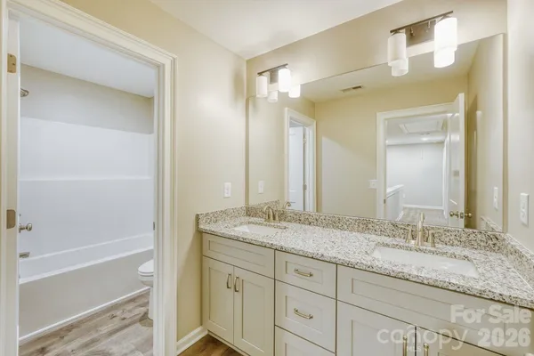 a bathroom with a granite countertop sink mirror and double