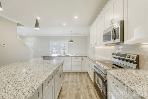 a kitchen with granite countertop a sink stainless steel appliances and cabinets