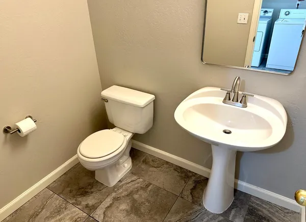 a bathroom with a toilet sink and mirror
