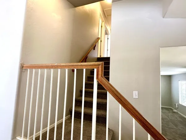 a view of staircase with railing and white walls