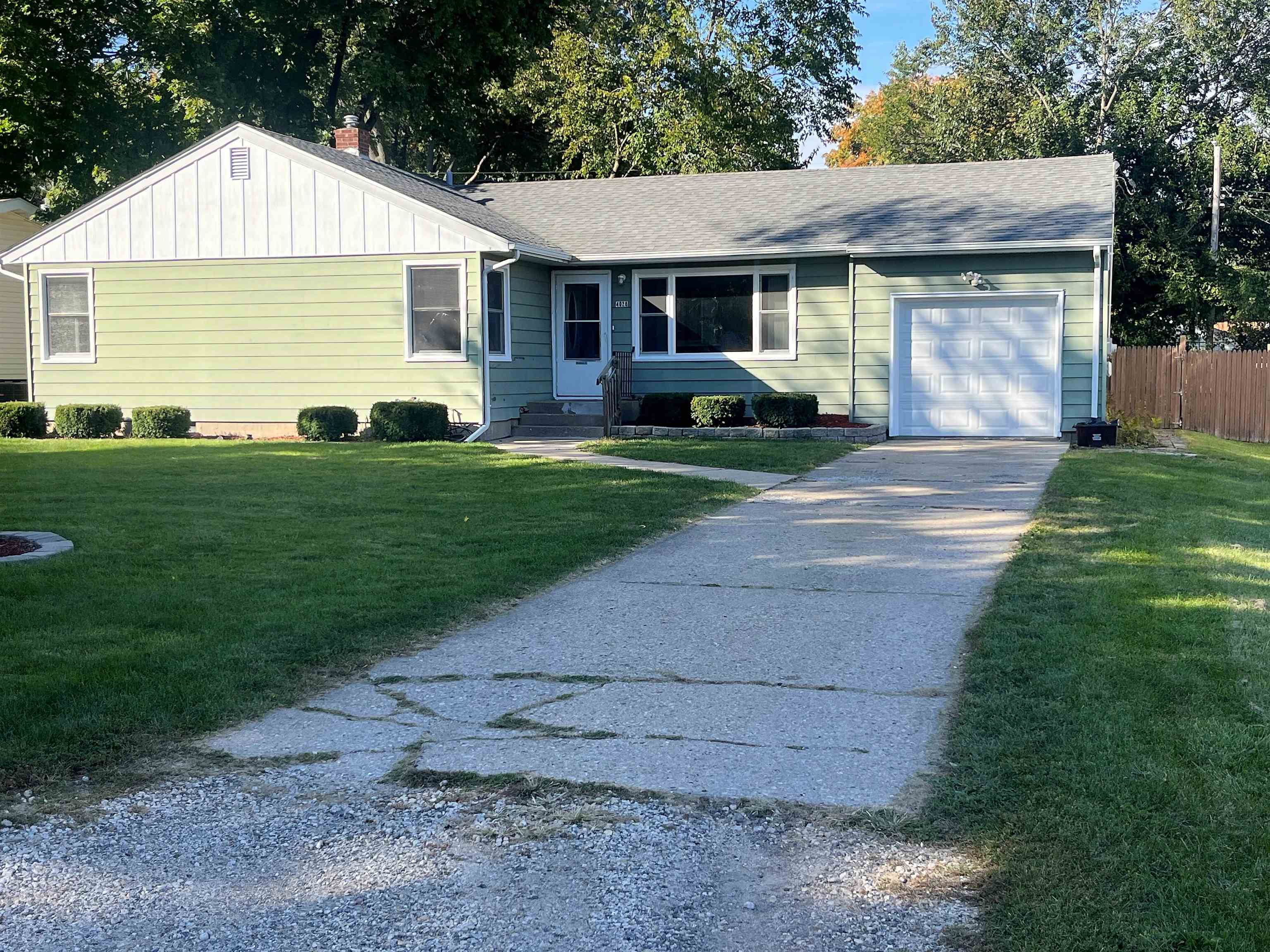 4026 Pinecrest Road Rockford, IL 61107 - Photo 2 of 27 a front view of a house with a garden