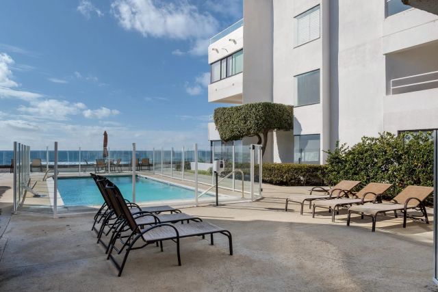 a swimming pool with outdoor seating and barbeque oven