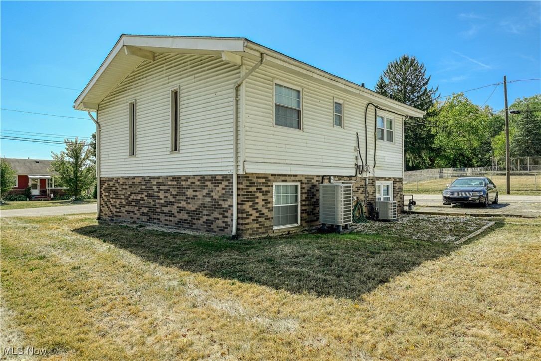 2359 Sanitarium Road Lakemore, OH 44250 - Photo 7 of 29 View of home's exterior with a yard and brick siding