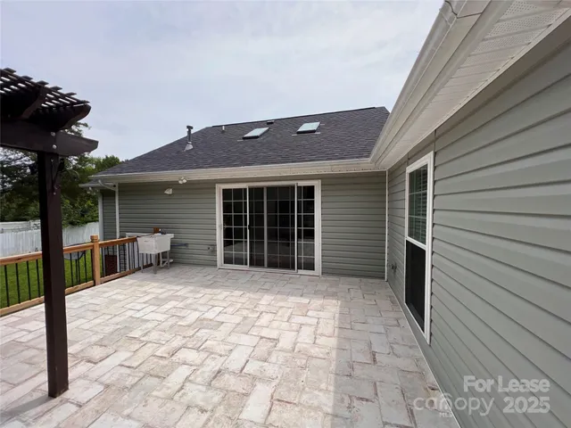 a view of a house with a large window and wooden fence