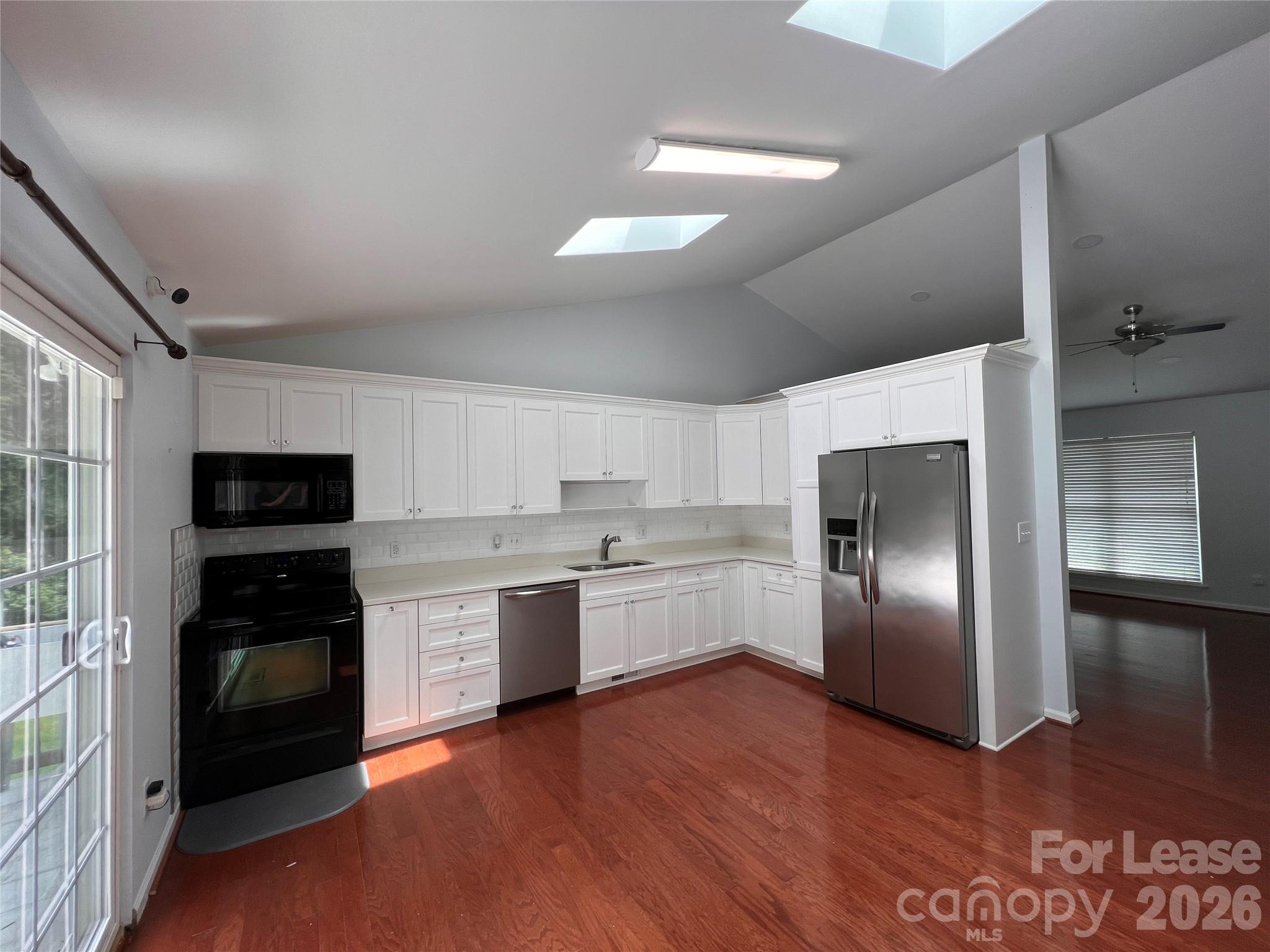 5312 Rea Road Charlotte, NC 28226 - Photo 10 of 34 a kitchen with stainless steel appliances granite countertop a refrigerator a stove top oven a sink and dishwasher with wooden floor