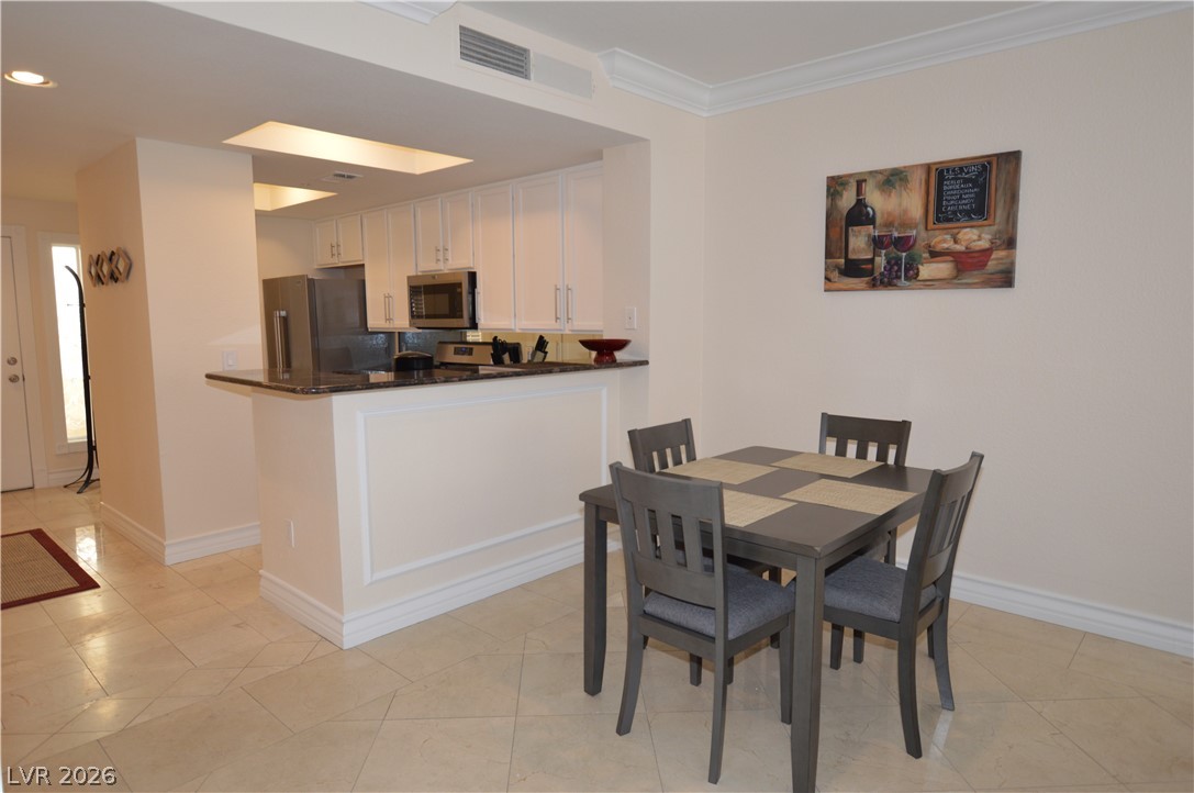 230 East Flamingo Road, Unit 334 Las Vegas, NV 89169 - Photo 3 of 37 Tile flooring and classic crown molding accent this inviting dining space adjacent to the kitchen.