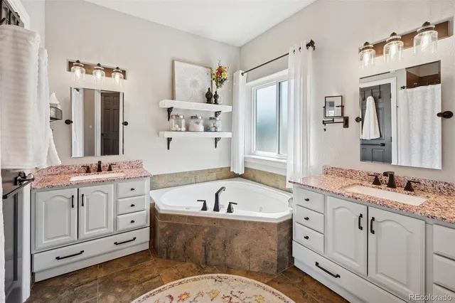 a bathroom with a tub sink and mirror