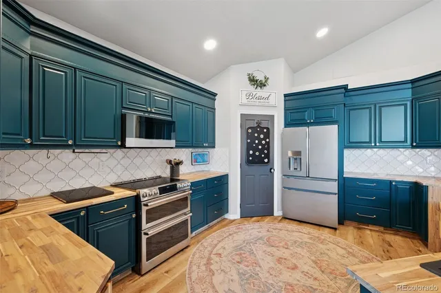 a kitchen with stainless steel appliances granite countertop a refrigerator and a stove top oven