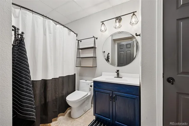 a bathroom with a toilet sink and mirror
