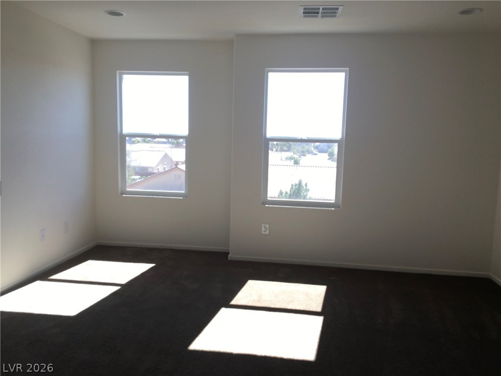 4650 Ranch House Road, Unit 9 North Las Vegas, NV 89031 - Photo 12 of 13 Natural light streams into this generously proportioned room, illuminating the dark flooring.