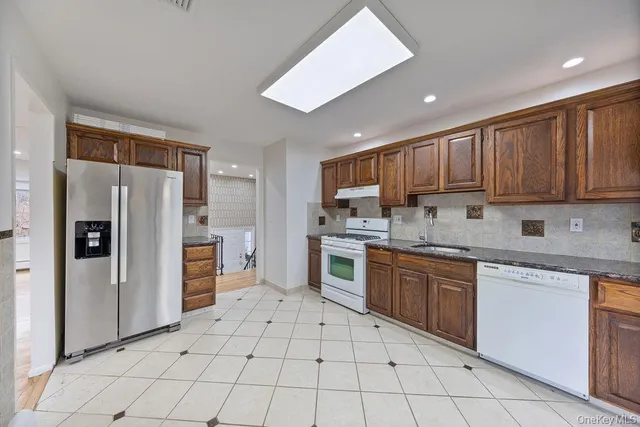 a kitchen with stainless steel appliances granite countertop a refrigerator and a stove top oven