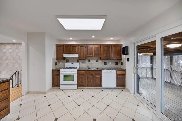 a kitchen with stainless steel appliances kitchen island granite countertop a refrigerator and a stove top oven