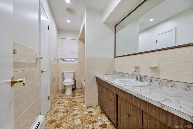 a spacious bathroom with a granite countertop sink a toilet and a shower
