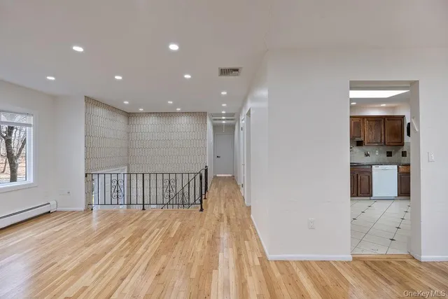 a view of a room with wooden floor and a bathroom