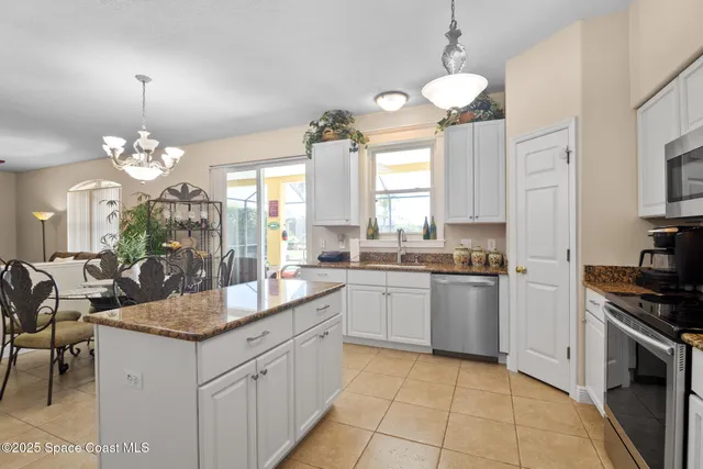 a kitchen with granite countertop stainless steel appliances a sink stove and cabinets