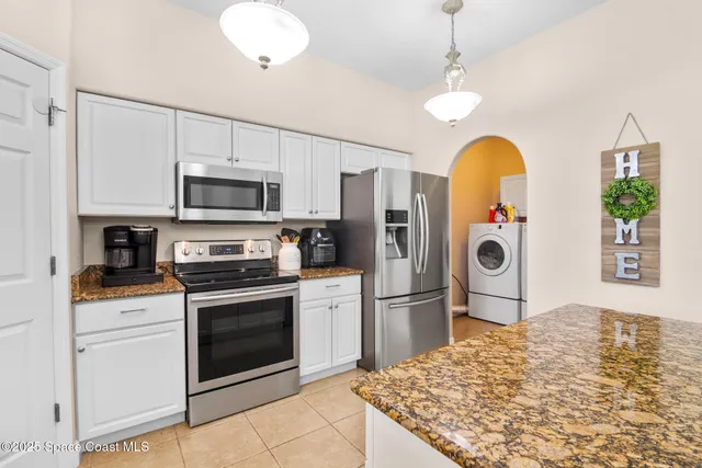 a kitchen with stainless steel appliances granite countertop a stove a refrigerator and a stove top oven