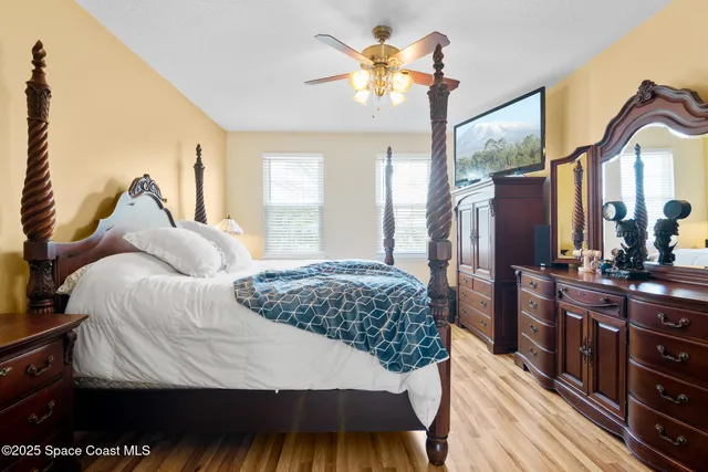 a bedroom with a bed a dresser and mirror